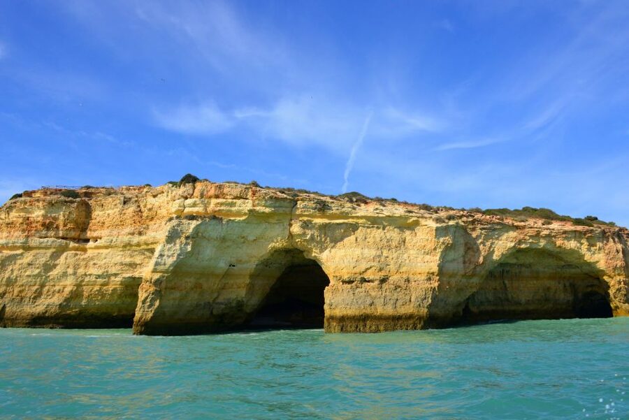 Kayakers under a limestone arch on the Algarve coast